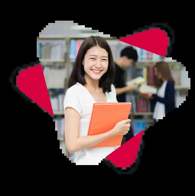 a ECCE teacher standing in library with a book and smiling